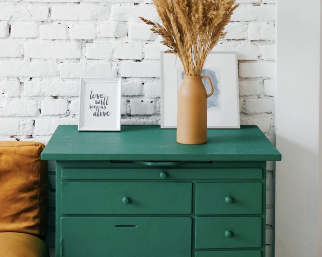 green drawer with white portraits and jar with wheat